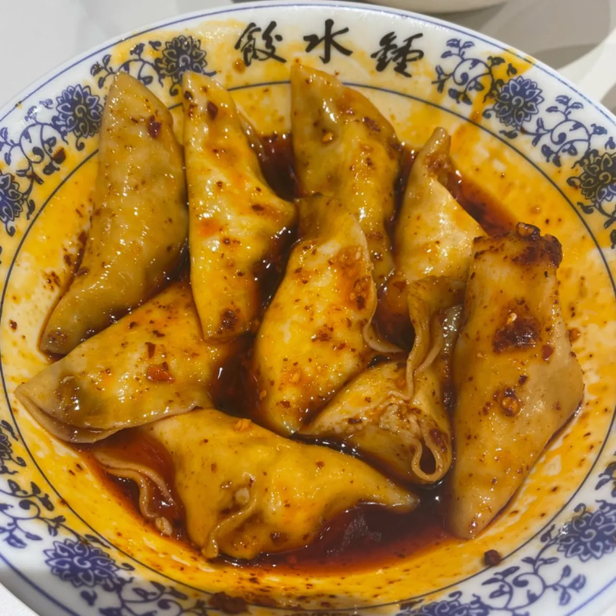 เกี๊ยวน้ำแซ่จง 钟水饺 เฉิงตู ราดน้ำมันพริกแดงในชามลายคราม ขอบชามพิมพ์อักษร 鍾水餃
