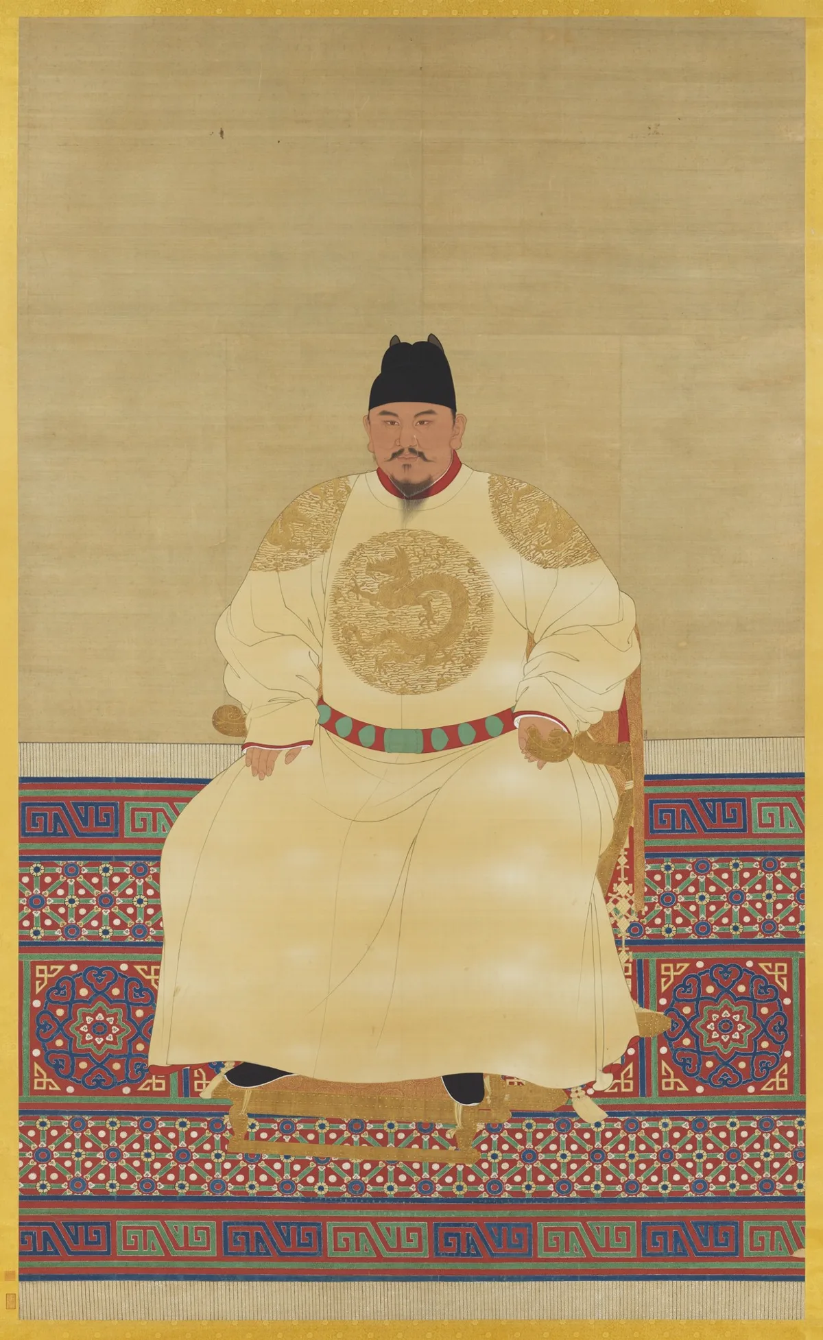 ภาพวาดจักรพรรดิจูหยวนจางประทับนั่งบนเก้าอี้ ฉลองพระองค์สีขาวนวลปักลายมังกรทอง สวมหมวกดำ คาดเข็มขัดแดงประดับหยก บนพรมลายสีแดงน้ำเงิน