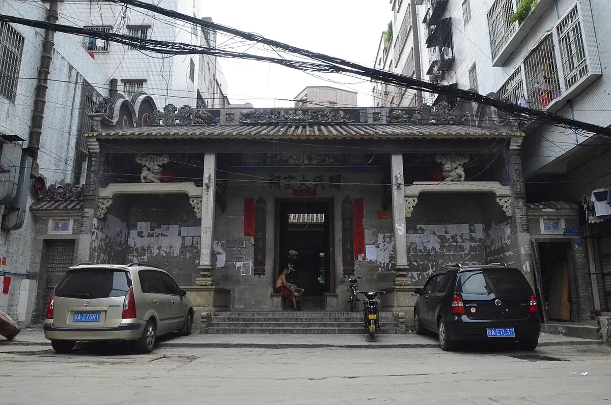 ศาลบรรพชนใหญ่ตระกูลกวาน 關氏大宗祠 แซ่กวง แซ่กวาน หมู่บ้านเซียวกัง กว่างโจว เสาหินสองต้น ล้อมด้วยตึกพักอาศัยและสายไฟ