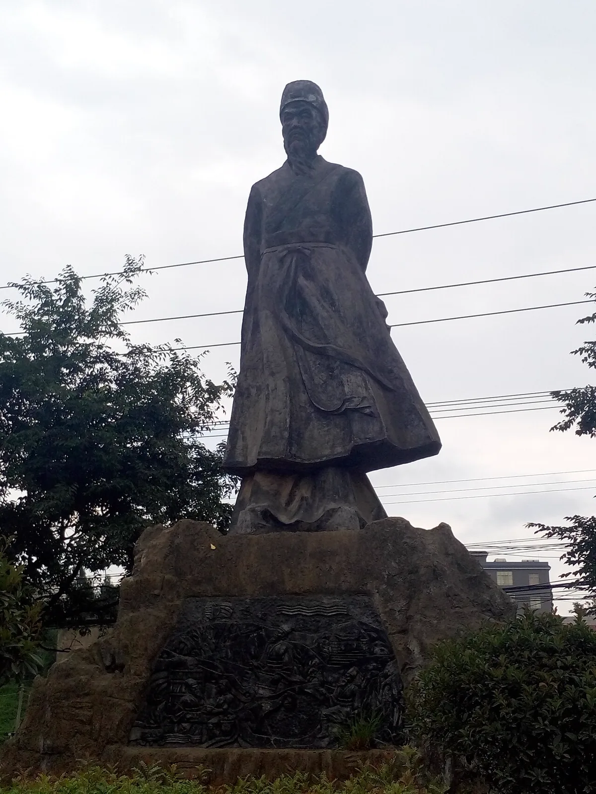 อนุสาวรีย์หินหลานเม่า 兰茂 บุคคลสำคัญแซ่หลาน แซ่ลั้ง สวมหมวกบัณฑิต ไว้เคราดก เสื้อคลุมยาวพลิ้ว บนฐานหินที่มีภาพสลักนูนต่ำ ตำบลหยางหลิน
