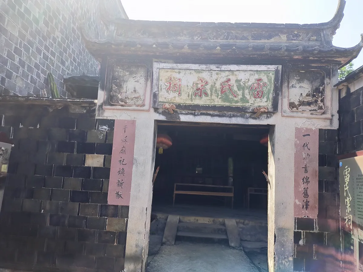 ประตูศาลบรรพชนแซ่ลุ้ย แซ่เหลย 雷氏宗祠 หมู่บ้านปั้นเยว่หลี่ อำเภอเสียผู่ ฝูเจี้ยน ผนังหินสีเข้ม คู่กลอนกระดาษสีชมพู