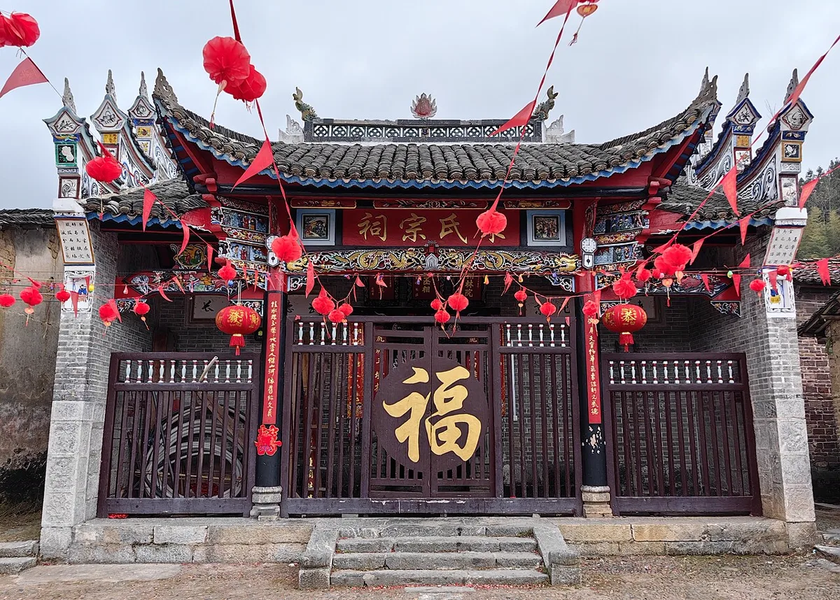 ประตูศาลบรรพชนตระกูลซ่ง ป้ายเหนือประตูเขียนว่า 宋氏宗祠 ประดับโคมแดงและธงสามเหลี่ยม หมู่บ้านเกาชุน