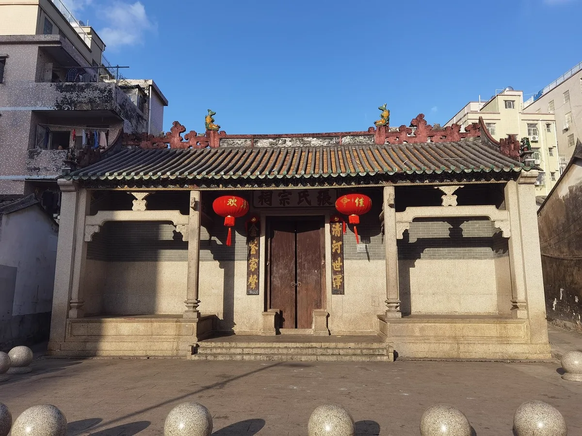 ศาลบรรพชนตระกูลเตีย แซ่จาง ที่เซินเจิ้น ป้ายเหนือประตูเขียนว่า 張氏宗祠 มีกลอนคู่ 金鑑家聲 และ 清河世澤 ข้างประตูไม้