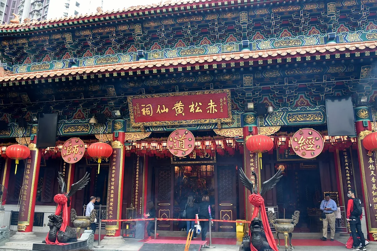 โถงวัดจีนหลังคาสีเหลือง ป้ายเหนือประตูอ่านว่า 赤松黃仙祠 มีวงกลมตัวอักษร 師 道 經