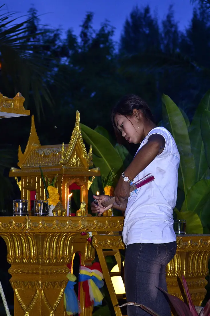 หญิงสาวจุดธูปไหว้ศาลพระภูมิยามเย็น การไหว้ประจำวันแบบไทย เทียบกับการไหว้ตี่จู้เอี๊ยะ